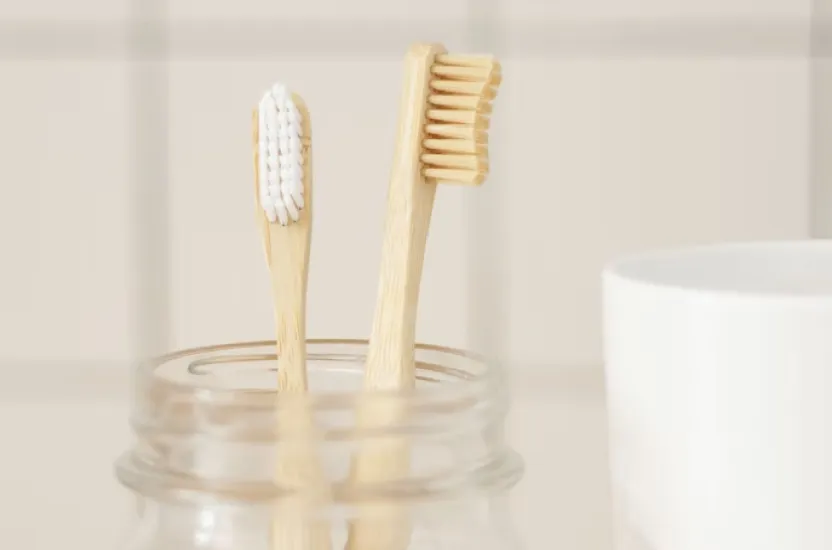 a couple of toothbrushes in a glass